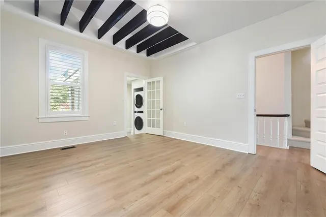 an empty room with wooden floor and windows