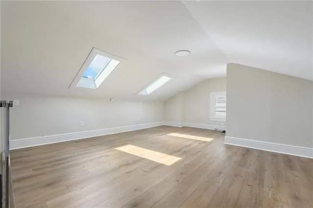 a view of an empty room with wooden floor and entryway