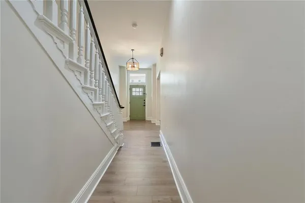 a view of a hallway with wooden floor and staircase