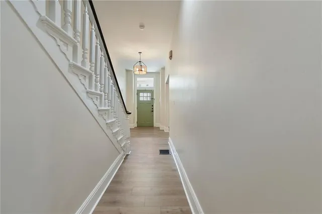 a view of a hallway with wooden floor and staircase