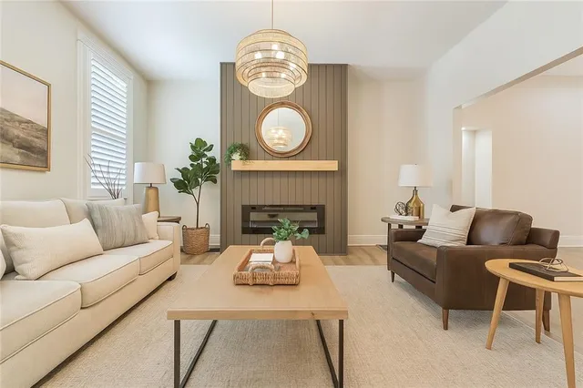 a living room with furniture a fireplace and a large window