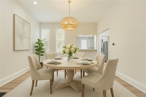 a dining room with furniture a potted plant and wooden floor