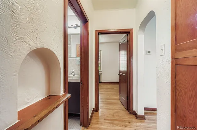 a view of a hallway with wooden floor and closet