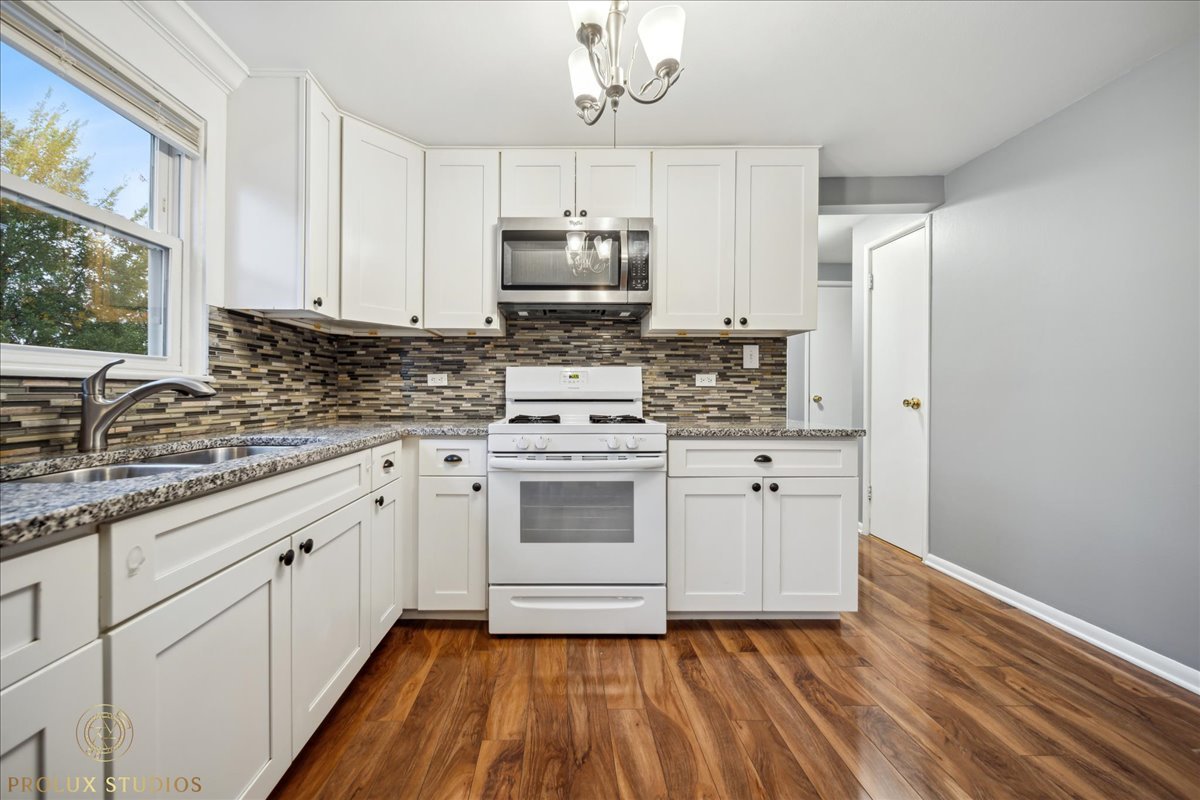 6935 West 64th Place, Unit 2A Chicago, IL 60638 - Photo 3 of 15 a kitchen with stainless steel appliances granite countertop a stove a sink and a refrigerator