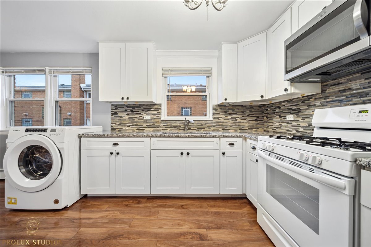 6935 West 64th Place, Unit 2A Chicago, IL 60638 - Photo 4 of 15 a kitchen with cabinets appliances and a window