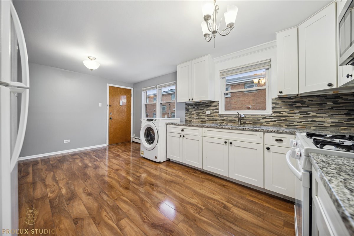 6935 West 64th Place, Unit 2A Chicago, IL 60638 - Photo 6 of 15 a kitchen with granite countertop a sink cabinets and stainless steel appliances