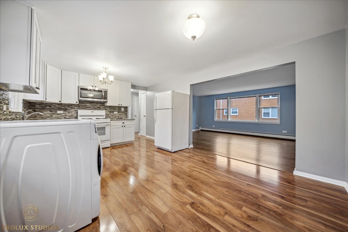 6935 West 64th Place, Unit 2A Chicago, IL 60638 - Photo 7 of 15 a kitchen with stainless steel appliances granite countertop a refrigerator a stove top oven and a sink with granite countertops