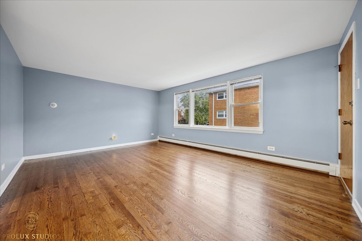 6935 West 64th Place, Unit 2A Chicago, IL 60638 - Photo 9 of 15 a view of an empty room with wooden floor and a window