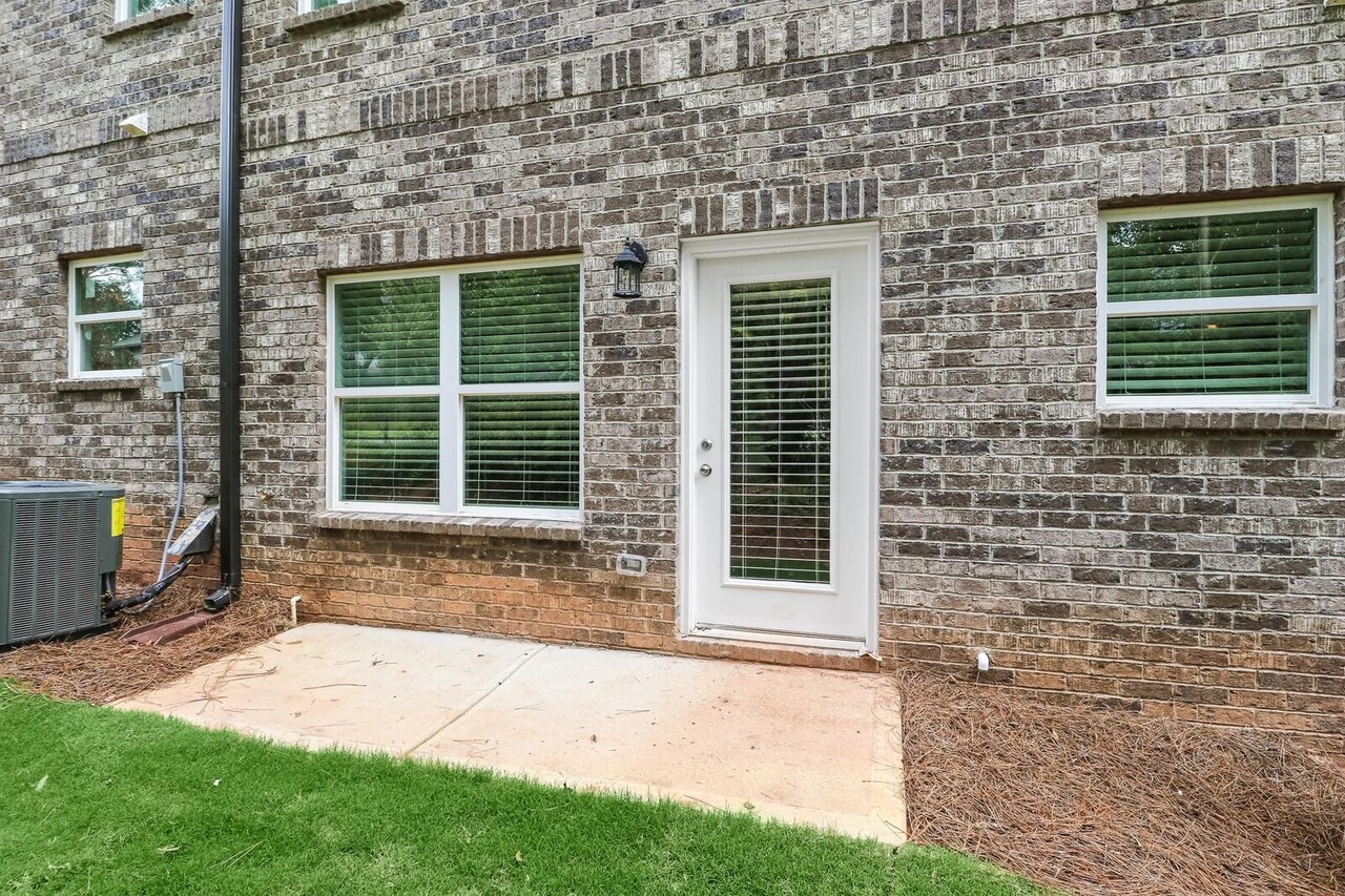 15 Sprayberry Road, Unit 11 Newnan, GA 30263 - Photo 16 of 18 a front view of a house with a yard and glass door