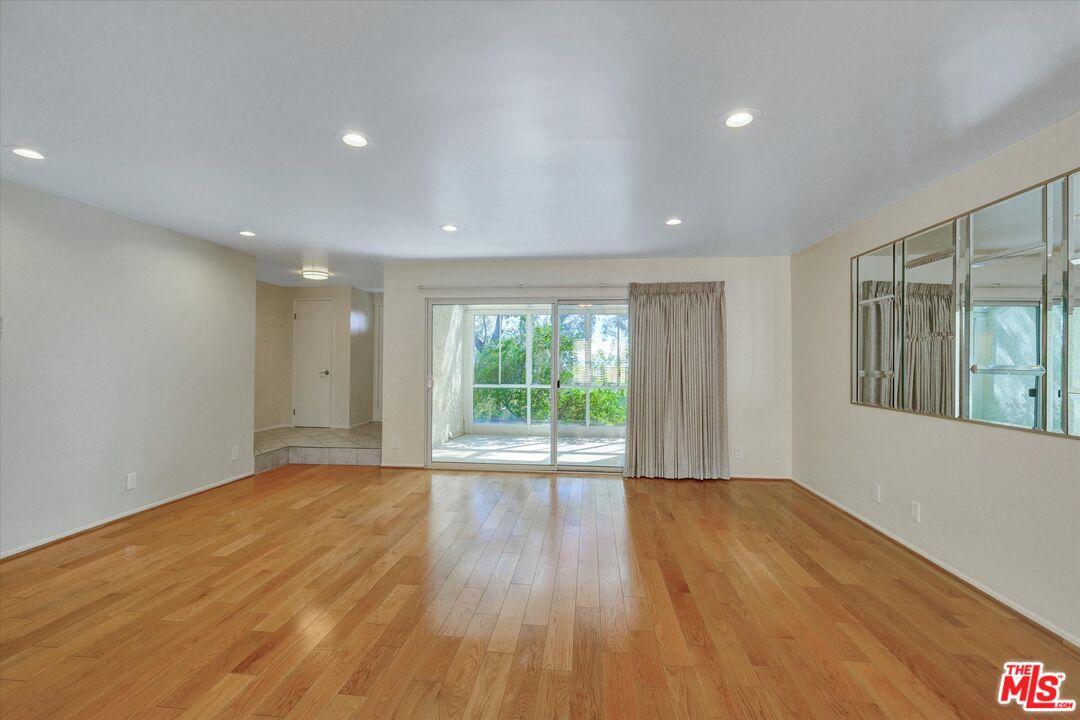 9634 Vía Rimini, Unit 118 Burbank, CA 91504 - Photo 12 of 35 a view of an empty room with wooden floor and a window