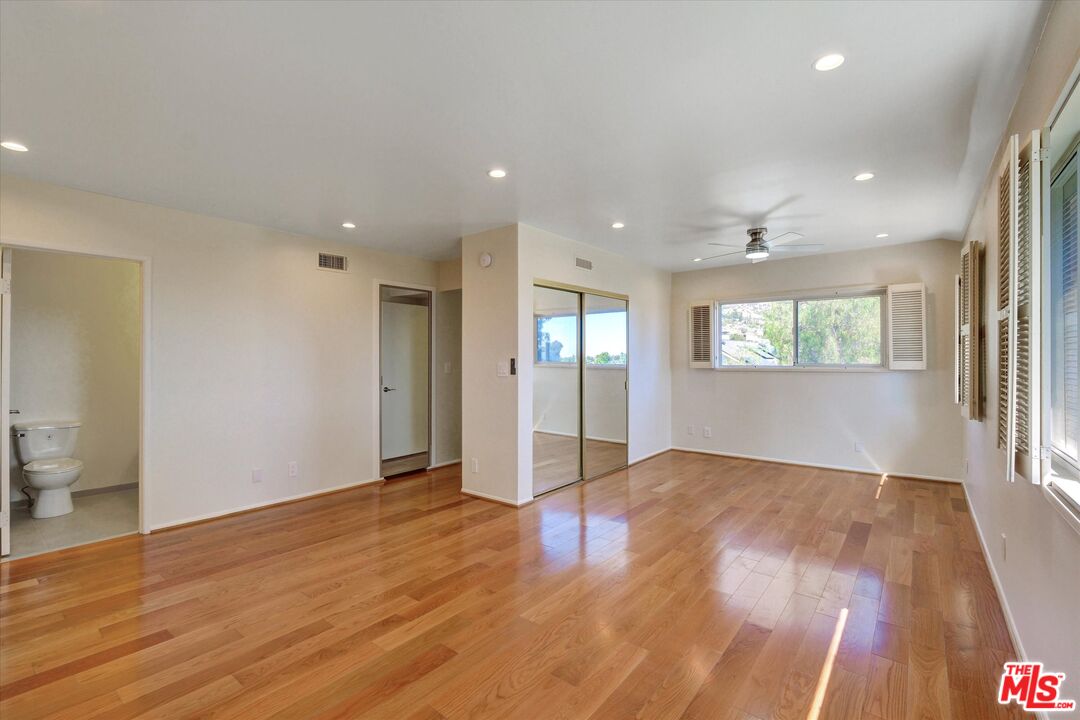 9634 Via Rimini, Unit 118 Sun Valley, CA 91504 - Photo 15 of 33 a view of empty room with wooden floor and fan