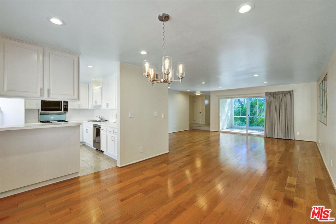 9634 Vía Rimini, Unit 118 Burbank, CA 91504 - Photo 2 of 35 a view of a kitchen with kitchen island wooden floor center island and windows