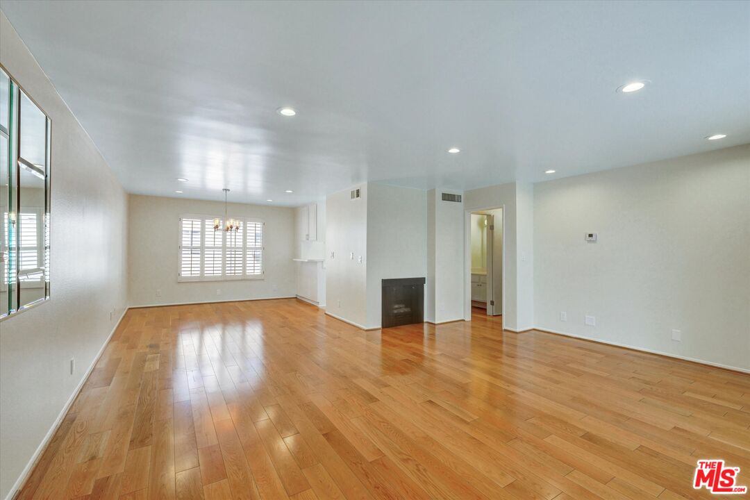 9634 Via Rimini, Unit 118 Sun Valley, CA 91504 - Photo 2 of 33 an empty room with wooden floor and windows
