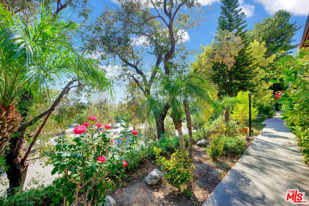 9634 Via Rimini, Unit 118 Sun Valley, CA 91504 - Photo 28 of 33 a view of a pathway covered with flower plants