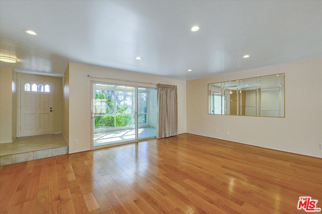 9634 Via Rimini, Unit 118 Sun Valley, CA 91504 - Photo 6 of 33 a view of an empty room with wooden floor and a window