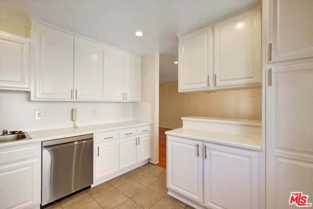 9634 Vía Rimini, Unit 118 Burbank, CA 91504 - Photo 7 of 35 a kitchen with white cabinets