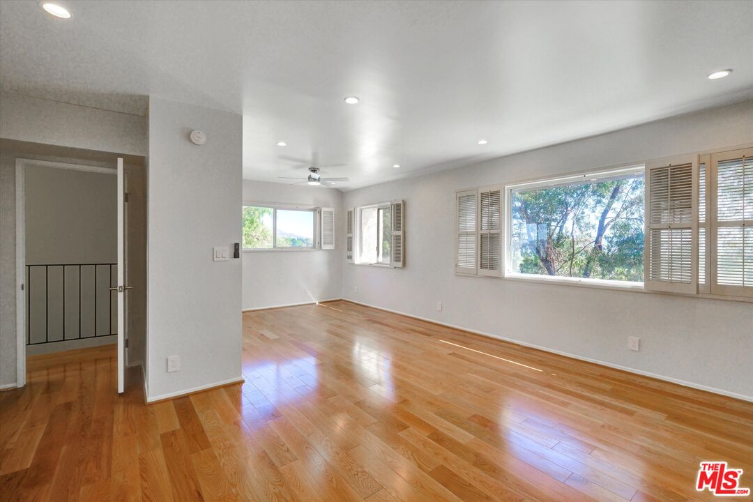 9634 Vía Rimini, Unit 118 Burbank, CA 91504 - Photo 8 of 35 an empty room with wooden floor and windows