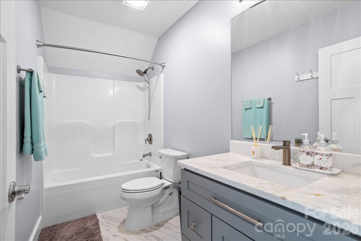 24 Mink Farm Road Leicester, NC 28748 - Photo 26 of 35 a bathroom with a granite countertop sink toilet a shower and a mirror