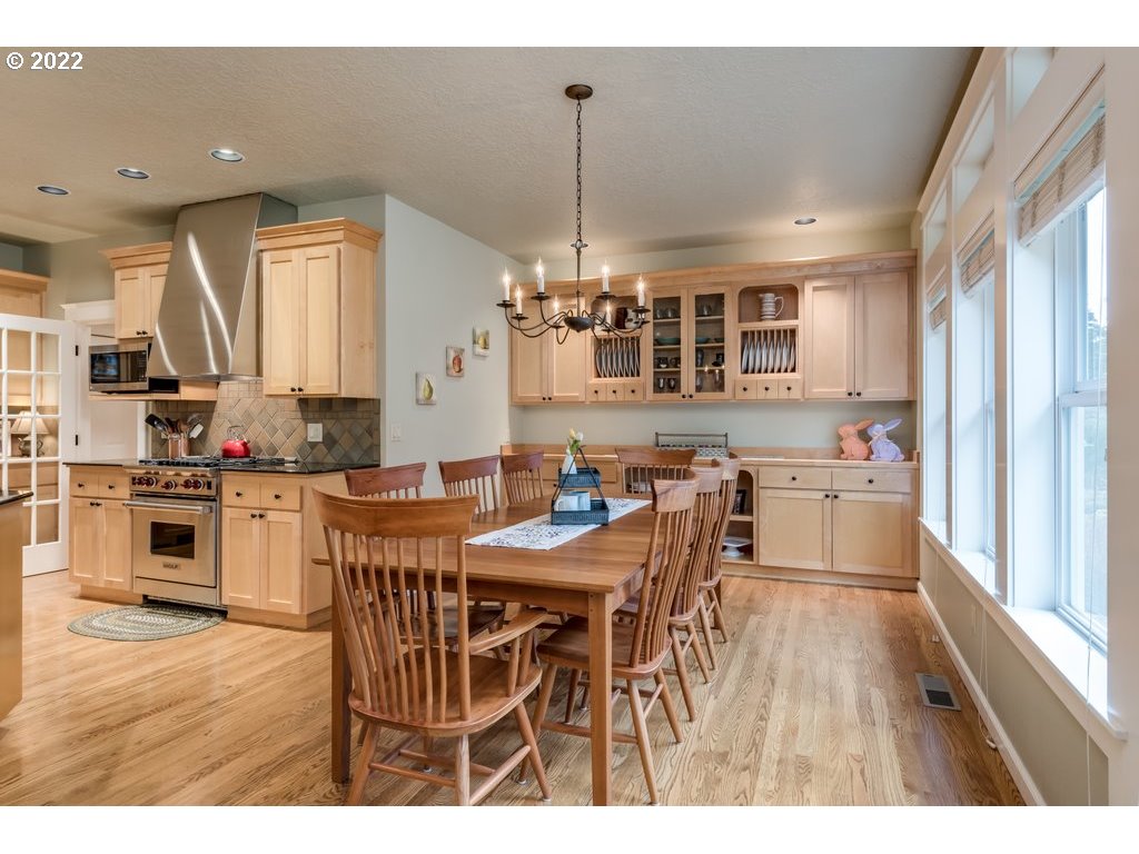 13831 South Carus Road Oregon City, OR 97045 - Photo 17 of 32 a open kitchen with stainless steel appliances granite countertop a stove top oven a sink dishwasher and white cabinets with wooden floor