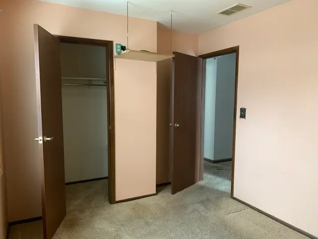a view of a refrigerator in kitchen and white cabinets