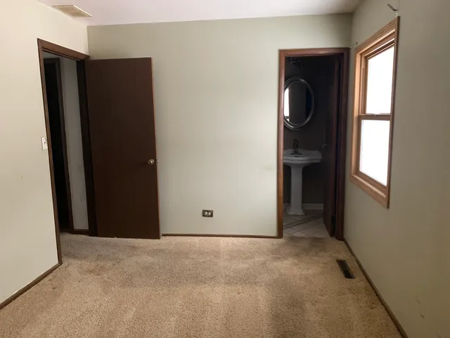 an empty room with closet and windows