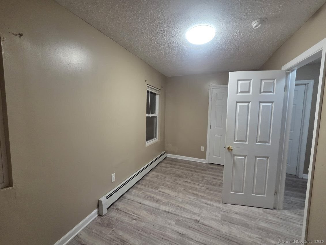 63 Seyms Street Hartford, CT 06120 - Photo 11 of 12 an empty room with wooden floor and windows