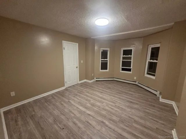 a view of a livingroom with wooden floor and window