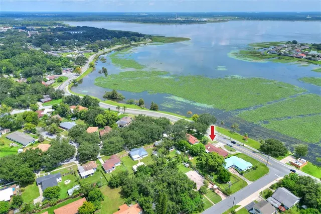 an aerial view of a houses with a yard and lake view