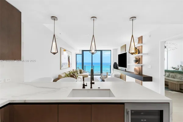 a kitchen with a sink a center island and a wooden floor