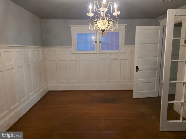 a view of a livingroom with wooden floor kitchen and a window