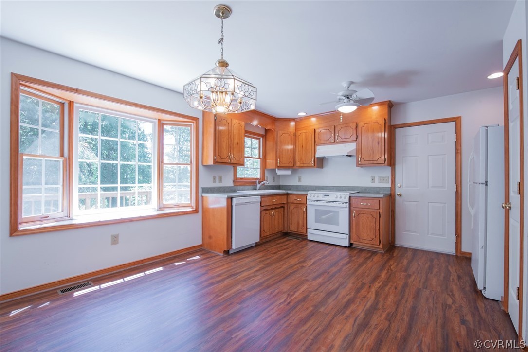 21417 Courthouse Road Dinwiddie, VA 23841 - Photo 14 of 50 a kitchen with stainless steel appliances granite countertop wooden floors and white cabinets
