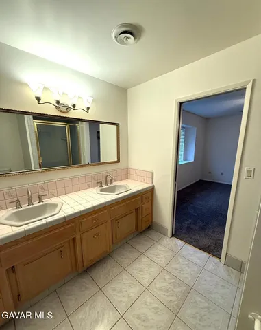 a spacious bathroom with a double vanity sink mirror and bathtub