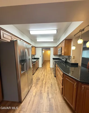 a kitchen with stainless steel appliances granite countertop a refrigerator and a sink