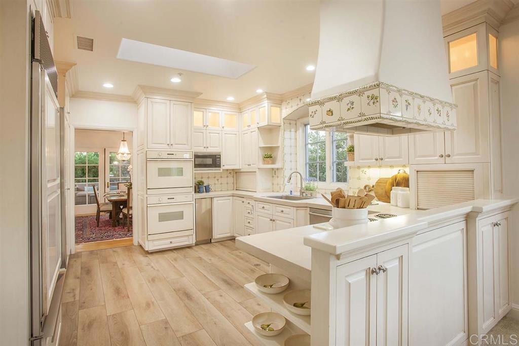 6019 La Flecha Rancho Santa Fe, CA 92067 - Photo 8 of 25 a kitchen with stainless steel appliances kitchen island granite countertop a sink and cabinets