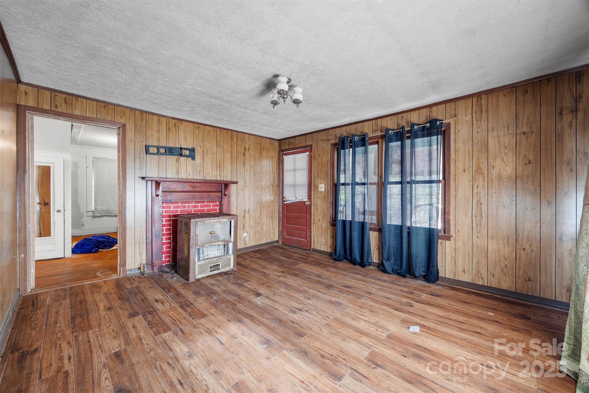 2012 State Road 30 Chester, SC 29706 - Photo 6 of 35 an empty room with fireplace chandelier and windows