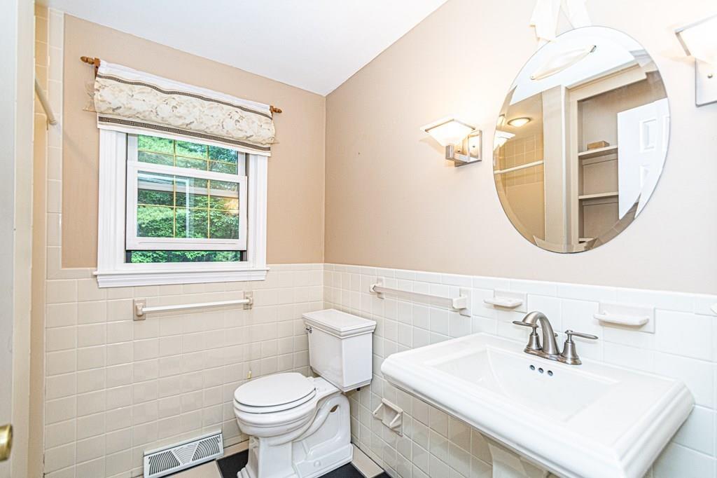 487 Boston Road Groton, MA 01450 - Photo 18 of 32 a bathroom with a sink a mirror a toilet and a window