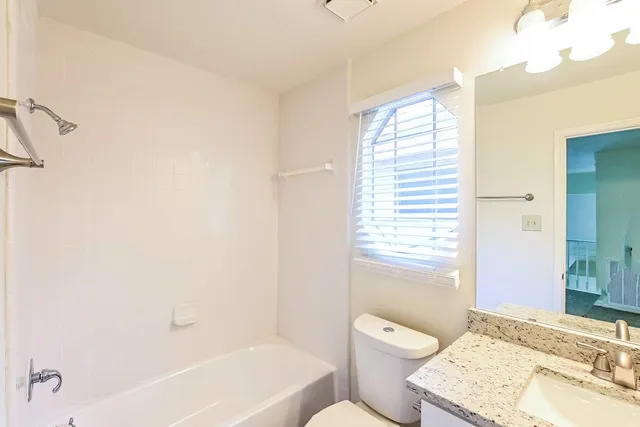 a bathroom with a granite countertop toilet a sink and a bathtub