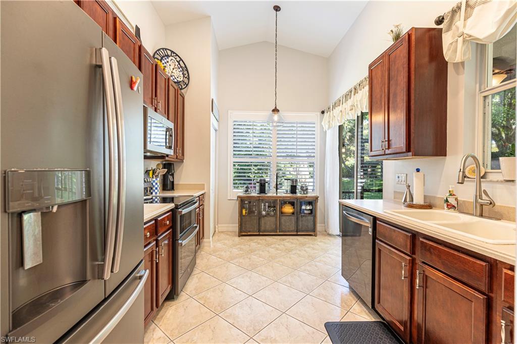 1364 Triandra Lane Naples, FL 34119 - Photo 5 of 27 a kitchen with stainless steel appliances granite countertop a refrigerator a sink dishwasher stove and oven