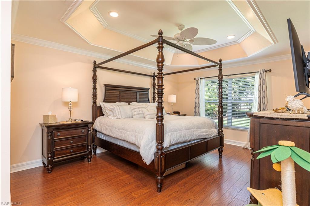 1364 Triandra Lane Naples, FL 34119 - Photo 6 of 27 a bedroom with a bed window and wooden floor
