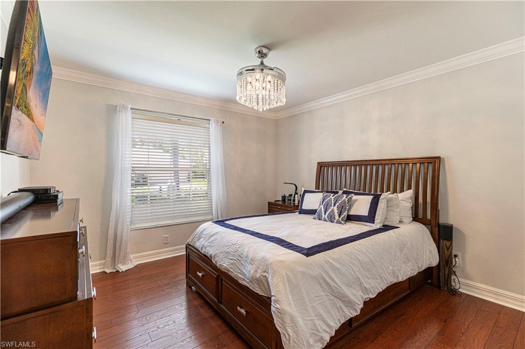 1364 Triandra Lane Naples, FL 34119 - Photo 8 of 27 a bedroom with a bed and wooden floor