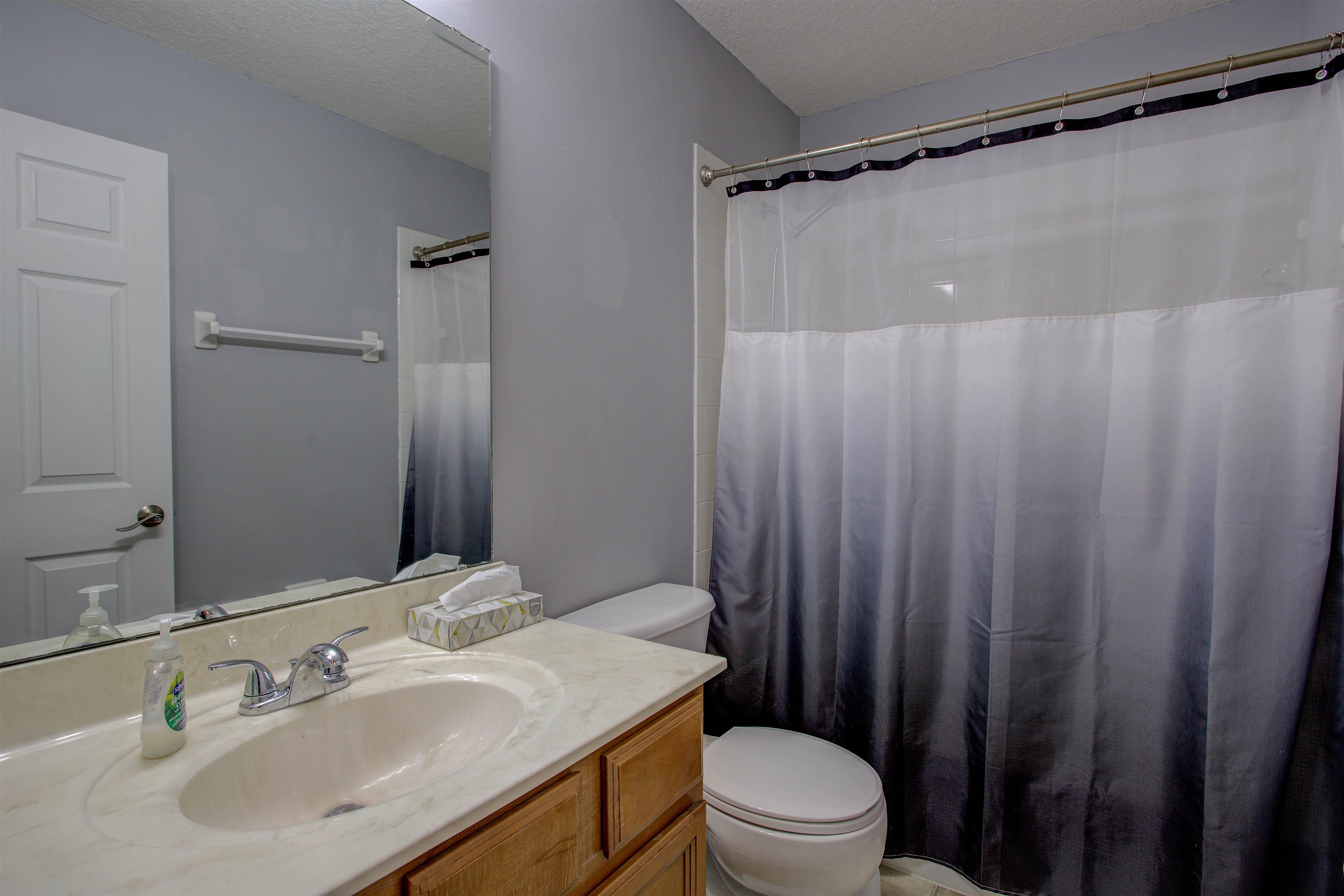 939 Silver Spring Court St. Augustine, FL 32092 - Photo 40 of 79 a bathroom with a sink a toilet a mirror and shower curtain