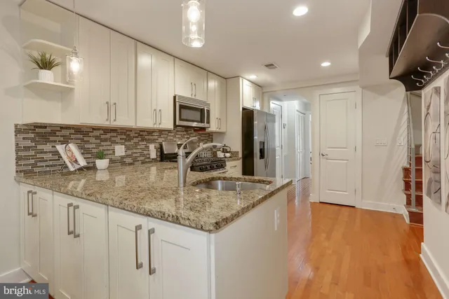 a kitchen with stainless steel appliances granite countertop a sink a stove and cabinets