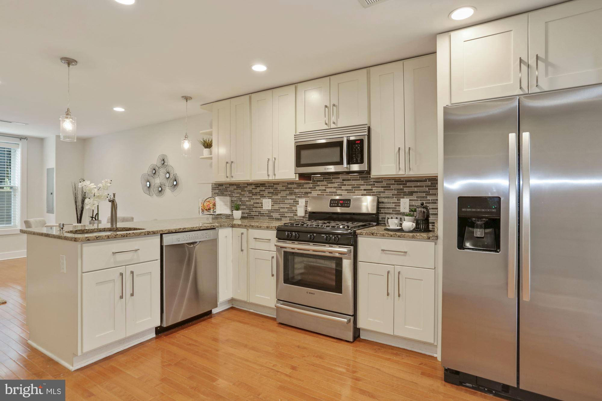 43 Hanover Place Northwest, Unit 1 Washington, DC 20001 - Photo 4 of 23 a kitchen with stainless steel appliances granite countertop a stove a sink and a refrigerator