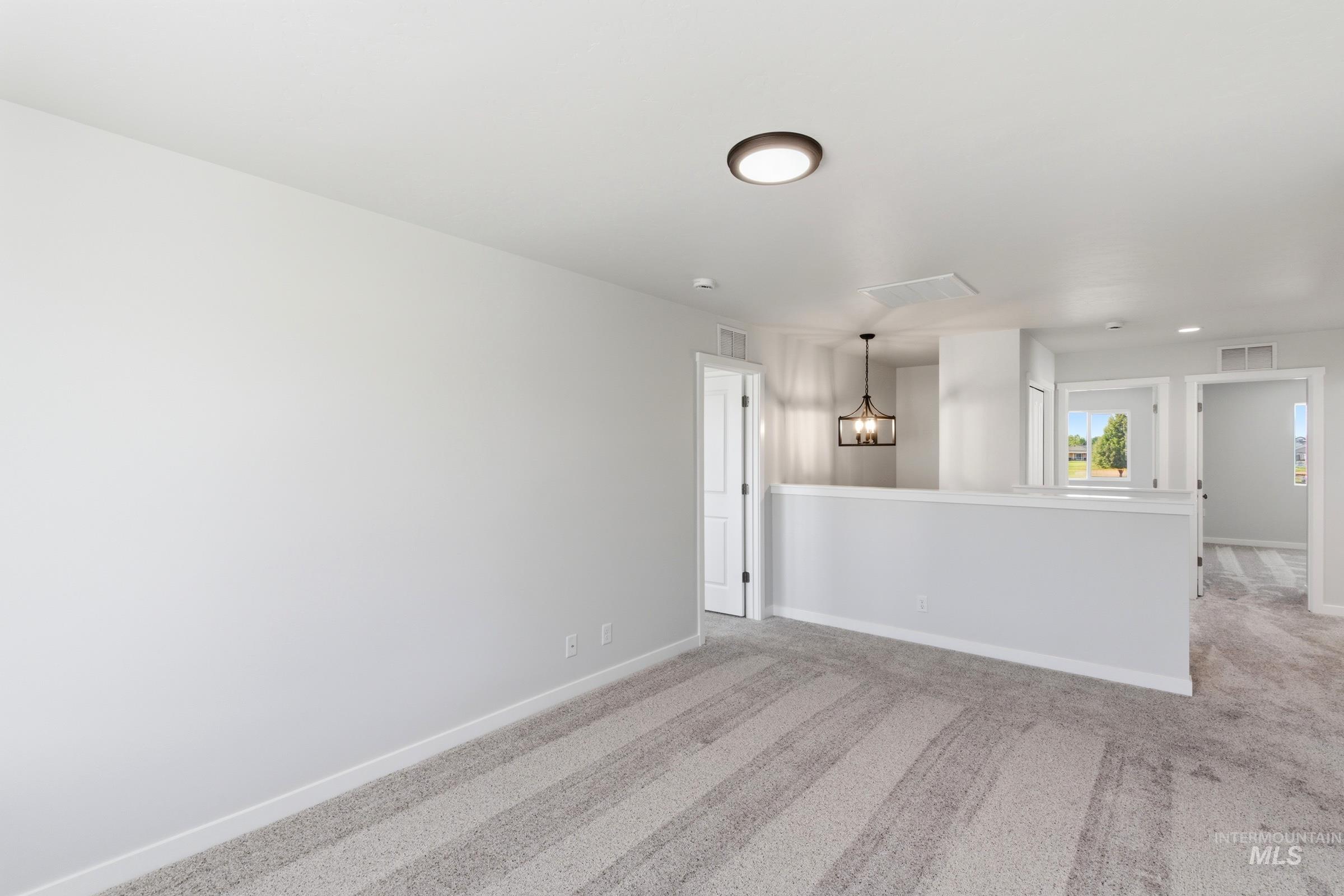 13677 Redway Court Caldwell, ID 83607 - Photo 18 of 35 Spacious upper-level area featuring light gray walls, gray patterned carpeting, and white trim