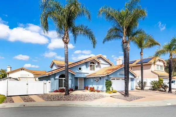 a front view of a building with palm trees
