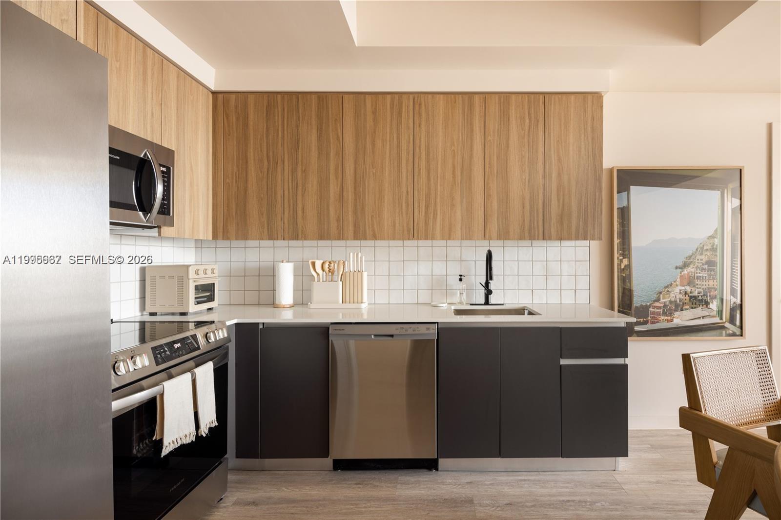 275 Southwest 6th Street, Unit 1110 Miami, FL 33130 - Photo 8 of 22 a kitchen with stainless steel appliances wooden cabinets and a sink