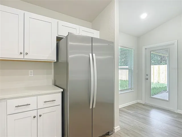 a kitchen with cabinets and a refrigerator