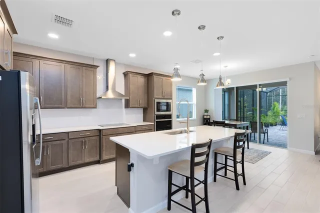 a kitchen with stainless steel appliances granite countertop a sink refrigerator and cabinets
