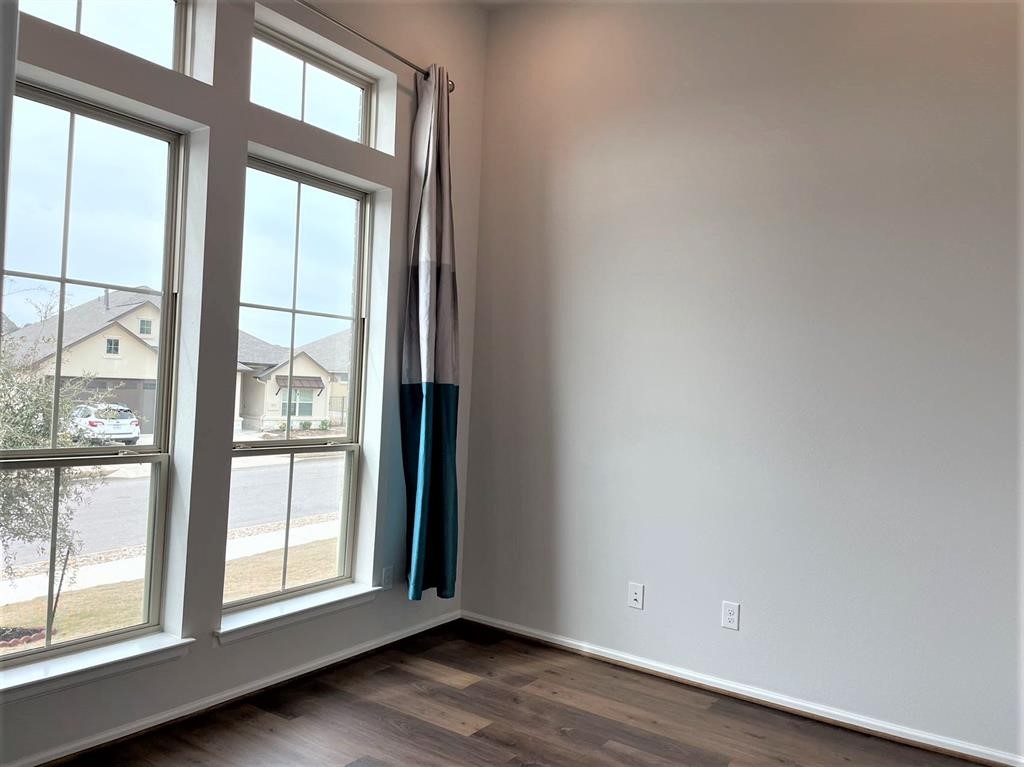 156 Santa Maria Street Georgetown, TX 78628 - Photo 5 of 39 an empty room with wooden floor and windows