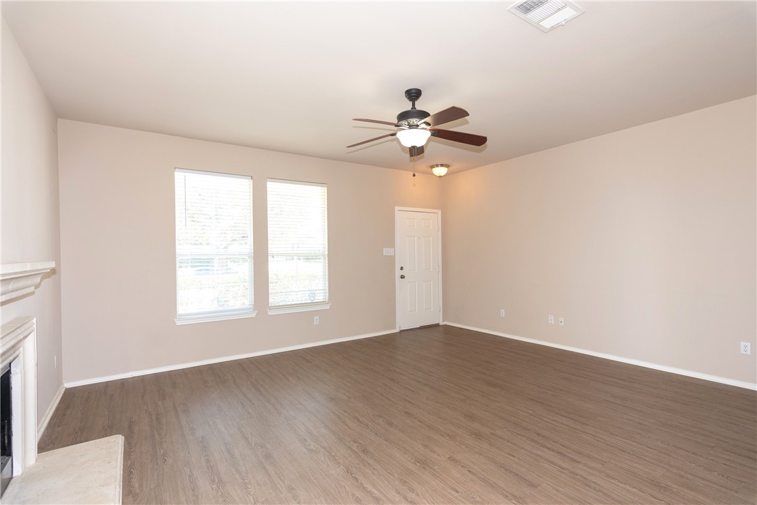 2605 Summerwalk Place Round Rock, TX 78665 - Photo 11 of 37 an empty room with wooden floor fan and windows